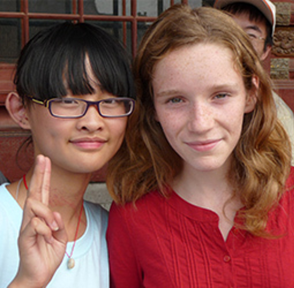 Twee meisjes poseren samen tijdens familiereis China.