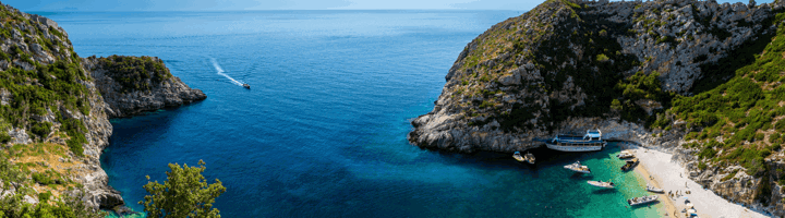 Rotsachtige baai met helderblauw water en strand aan de Albanese Rivièra, ideaal in de beste reistijd voor Albanië.