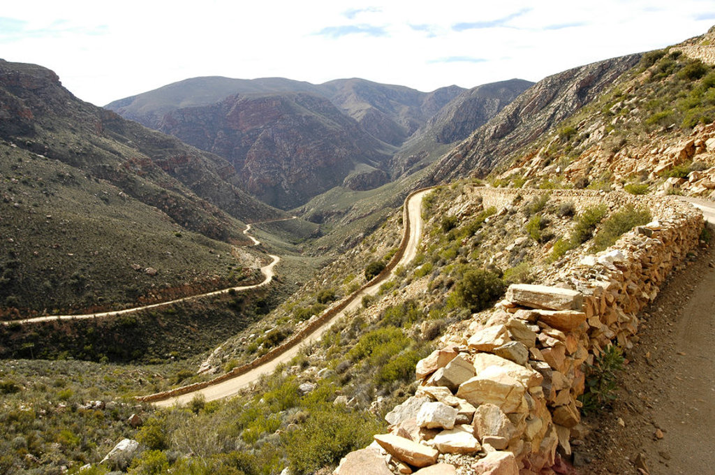 Kronkelende bergweg door een ruige vallei langs de Tuinroute in Zuid-Afrika.