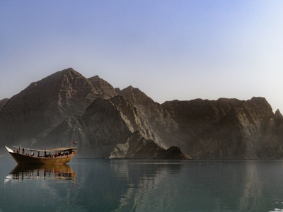 Traditionele dhow op de fjorden van Musandam in Oman, met ruige bergen op de achtergrond.