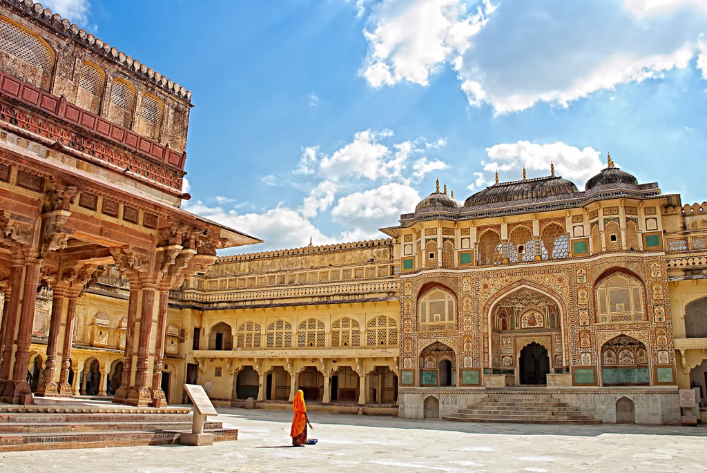 Binnenplaats van het Amber Fort in Jaipur, Noord-India, met rijk versierde paleisgevels onder een blauwe lucht.