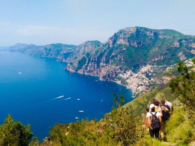 Wandelaars op bergpad met uitzicht op de Amalfikust en Positano aan zee, Italië.