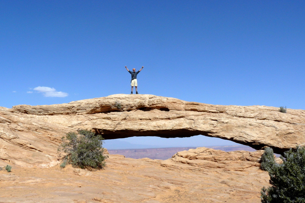 Reiziger op Mesa Arch in Canyonlands National Park tijdens groepsrondreis door West-Amerika.