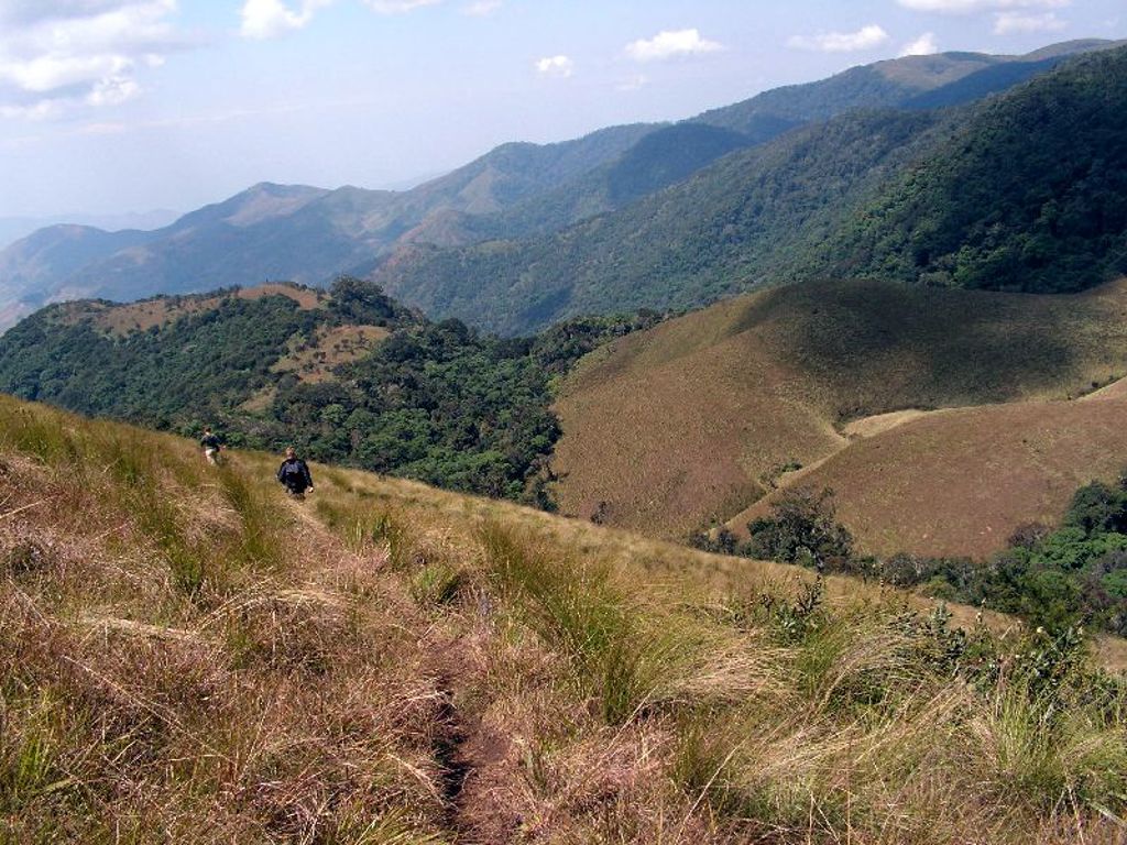 Wandelaars op een bergpad met uitzicht op groene bergen tijdens groepsrondreis Zambia, Malawi en Tanzania.