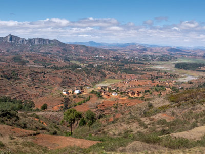 Panoramisch uitzicht op het berglandschap van Madagascar met terrassen, velden en een dorpje in de vallei.