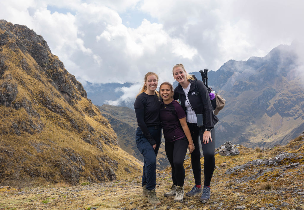 Jonge reizigers tijdens een trekking in de Andes in Peru, met bergen op de achtergrond.