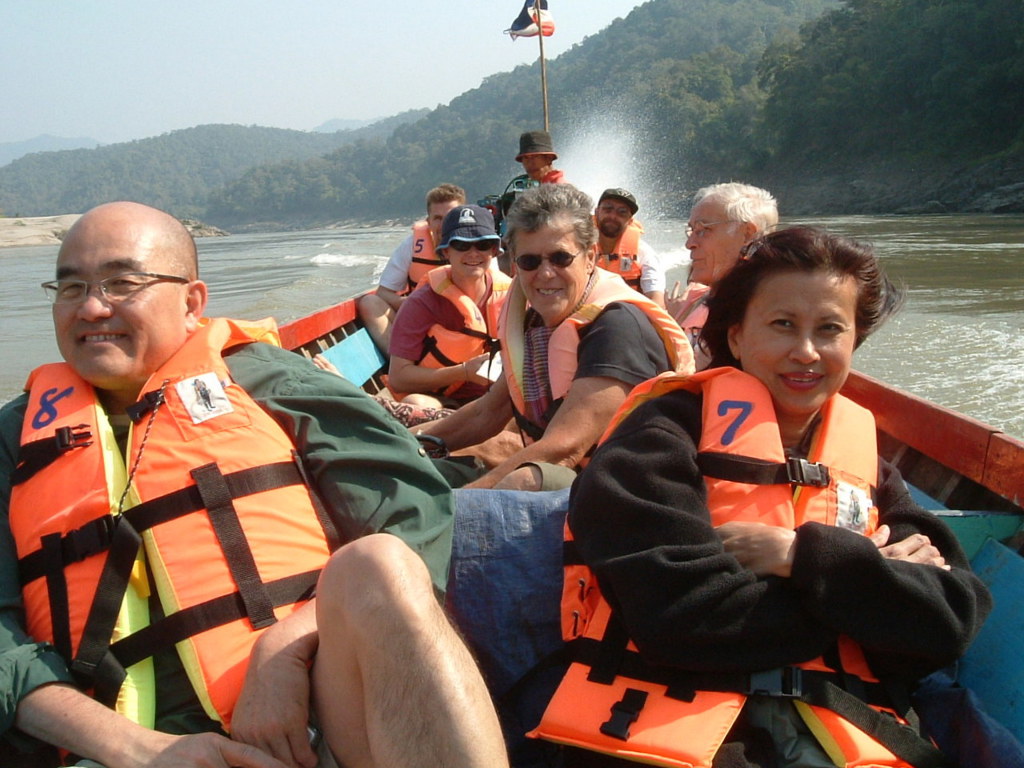 Groep reizigers met reddingsvesten tijdens een boottocht over de rivier in Zuid-Thailand.
