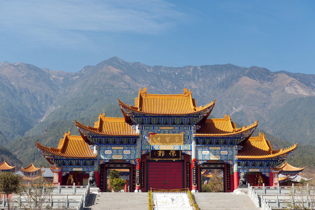 Traditionele Chinese tempel met gouden daken tegen een berglandschap, Familiereis China.