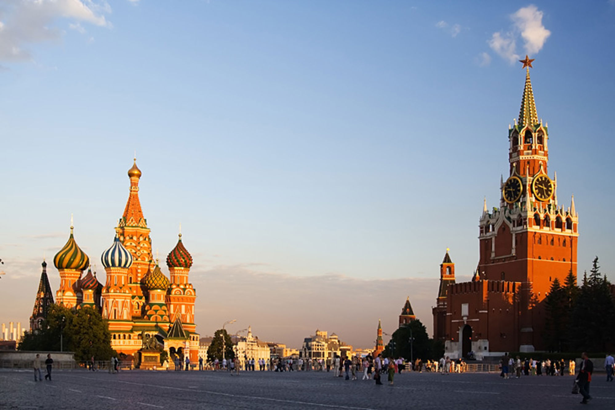 Rode Plein in Moskou met de Basiliuskathedraal en de Spasskaja-toren van het Kremlin bij zonsondergang.