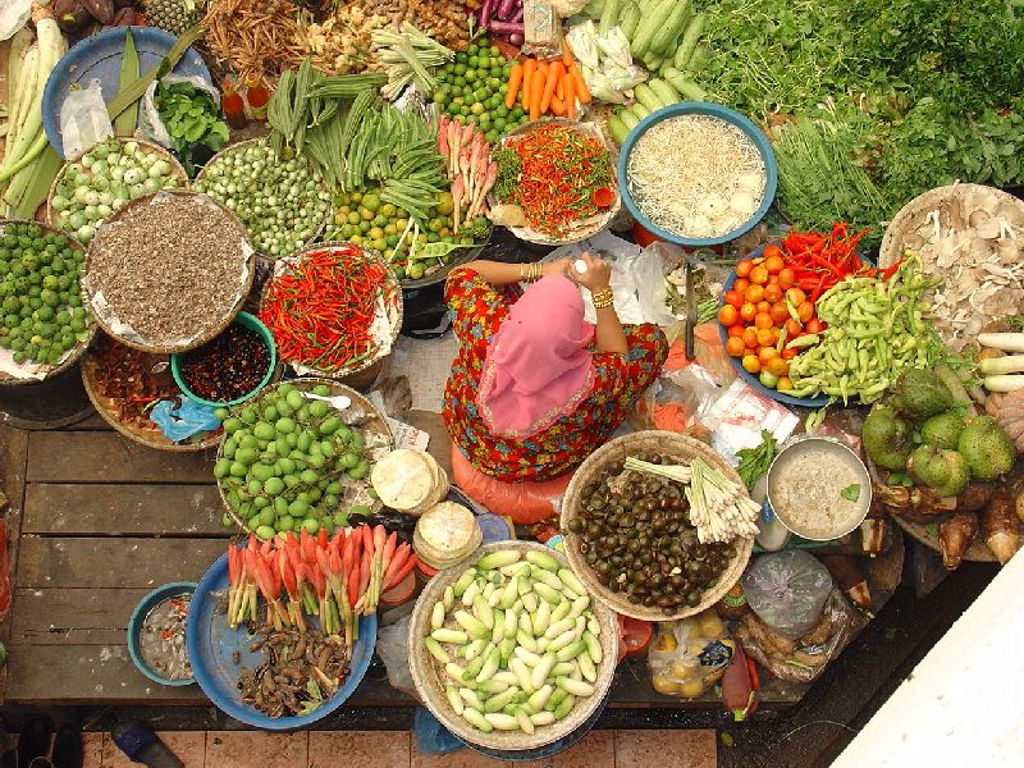 Groentemarkt in Maleisië met kleurrijke kruiden, chilipepers en groenten tijdens rondreis Maleisië hoogtepunten.