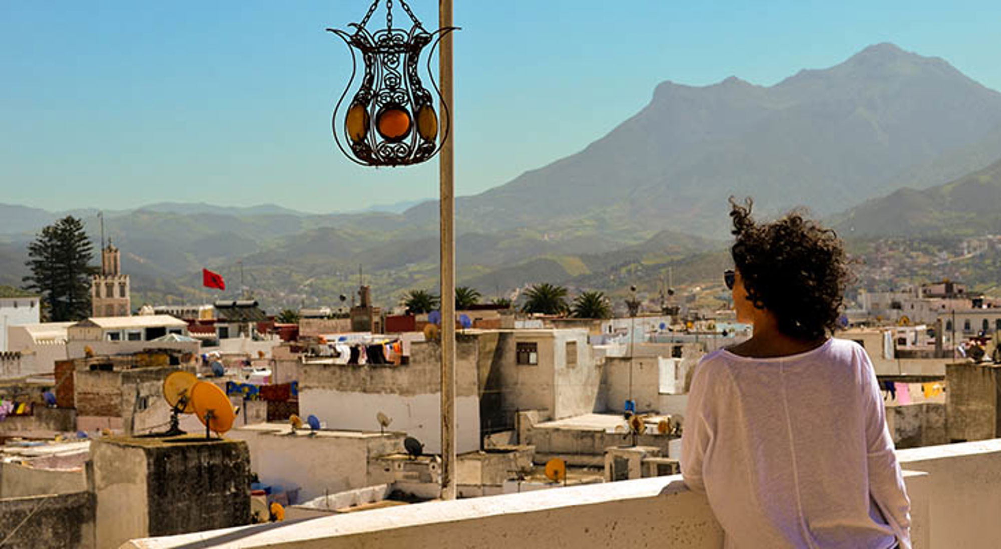 Tétouan Uitzicht over de daken van Chefchaouen met de Rifgebergte op de achtergrond, gezien vanaf een terras.
