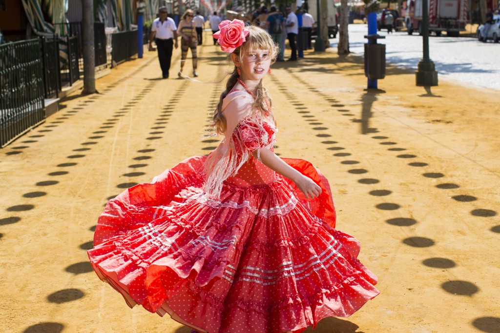 Meisje in rode flamencojurk draait op een straat in Andalusië, Spanje.