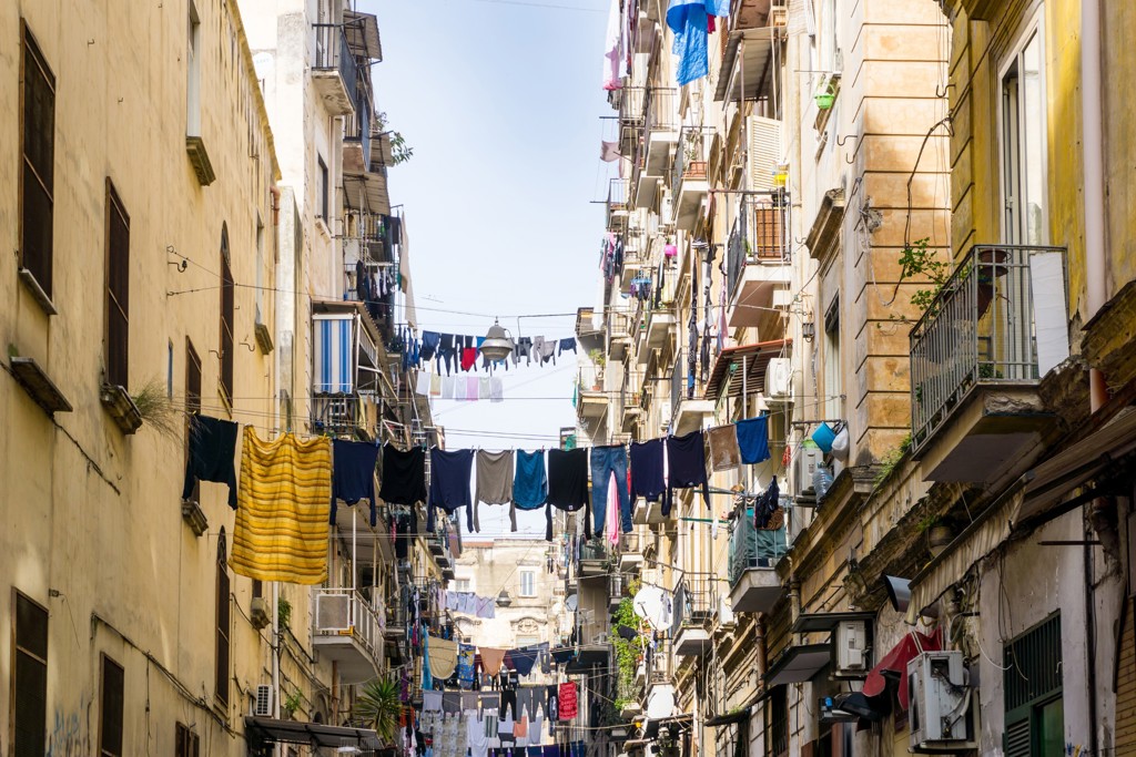 Smalle straat in Italië met wasgoed aan lijnen tussen balkons, tijdens rondreis langs de Amalfikust.