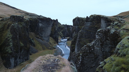 Met mos begroeide kloof met rivier in winters landschap in IJsland.