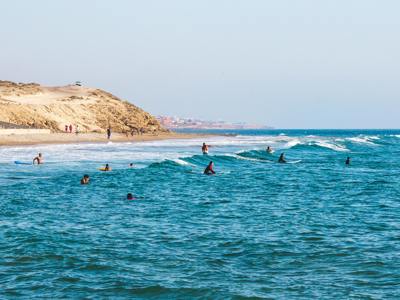 Surfers in de golven bij de kust van Marokko tijdens Route Marokko, 14 dagen.
