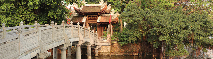 Houten tempel bij het Hoan Kiem-meer in Hanoi, Vietnam, met stenen brug over het water.