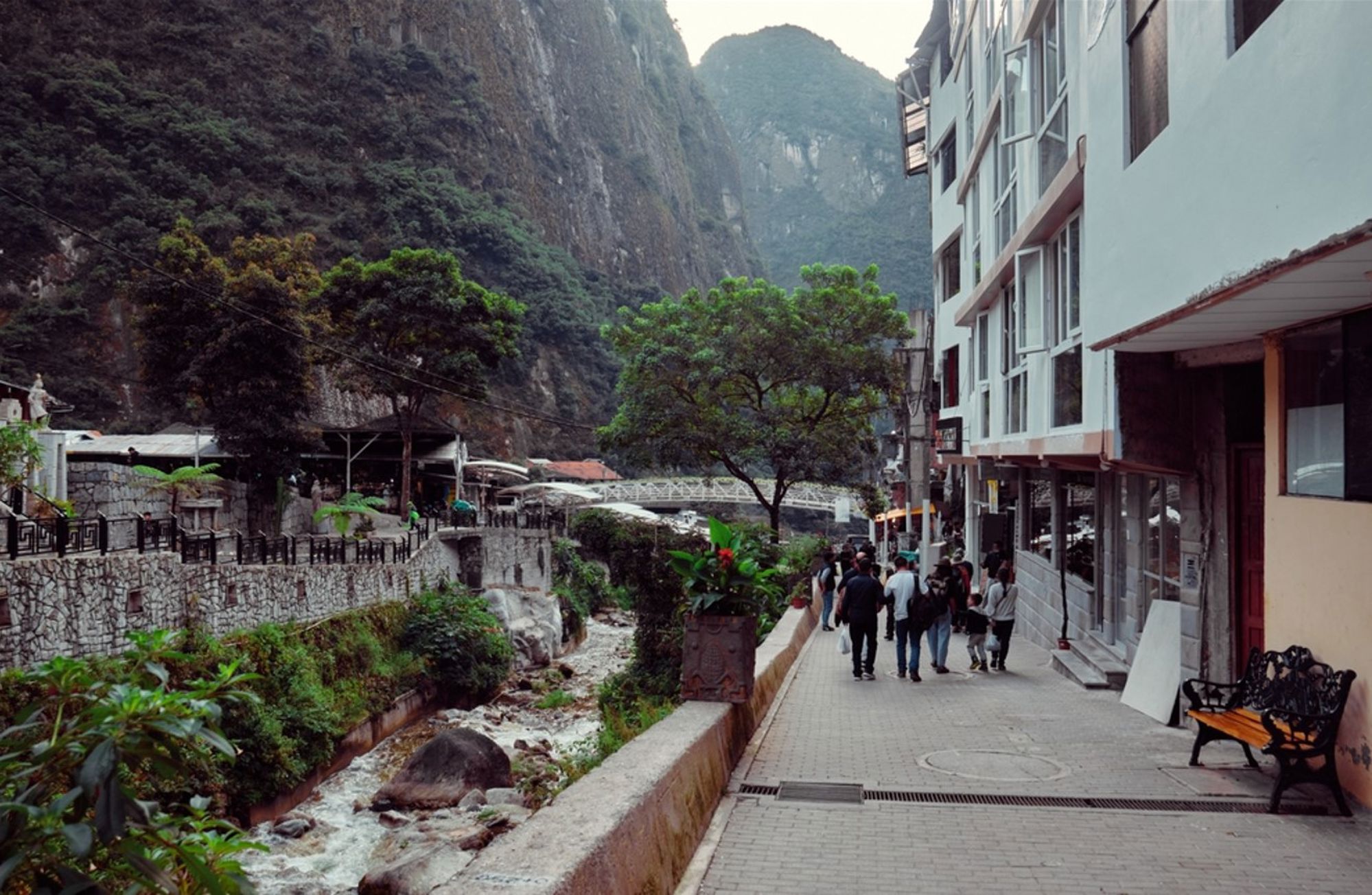 Straat in Aguas Calientes met rivier en bergen op de achtergrond, toegangspoort naar Machu Picchu in Peru.