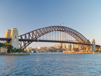 Sydney Harbour Bridge bij zonsondergang, met skyline en havenwater in Australië.