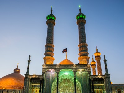 Verlichte minaretten en gouden koepel van de Fatima Masumeh-schrijn in Qom tijdens Route Iran, 14 dagen.