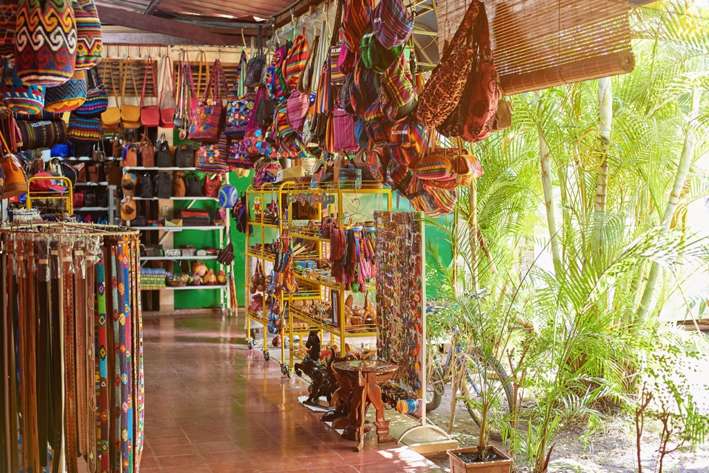 Souvenirwinkel in Nicaragua met kleurrijke tassen, riemen en handwerk in een overdekte markthal.