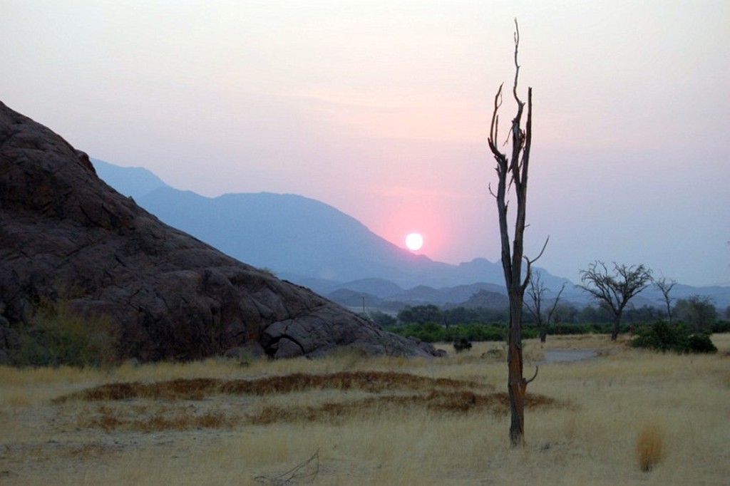 Zonsondergang boven rotslandschap en savanne in Namibië, Botswana en Zimbabwe.