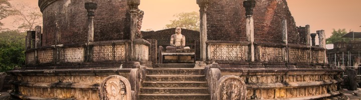Vatadage-tempelruïne in Polonnaruwa, Sri Lanka, met stenen trap en boeddhabeeld bij zonsondergang.