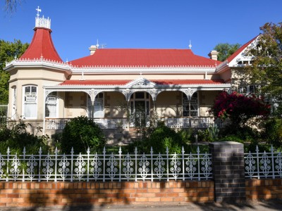 Historisch huis met rood dak en sierlijke veranda langs de Route Zuid Afrika.