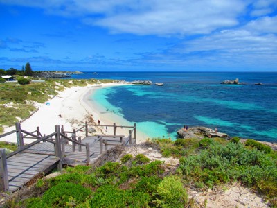 Uitzicht op wit zandstrand en turquoise zee bij Rottnest Island in West-Australië, met houten trap naar het strand.