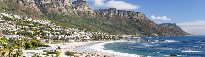 Panorama van Camps Bay met zandstrand, kustlijn en de Twaalf Apostelen-bergen bij Kaapstad.