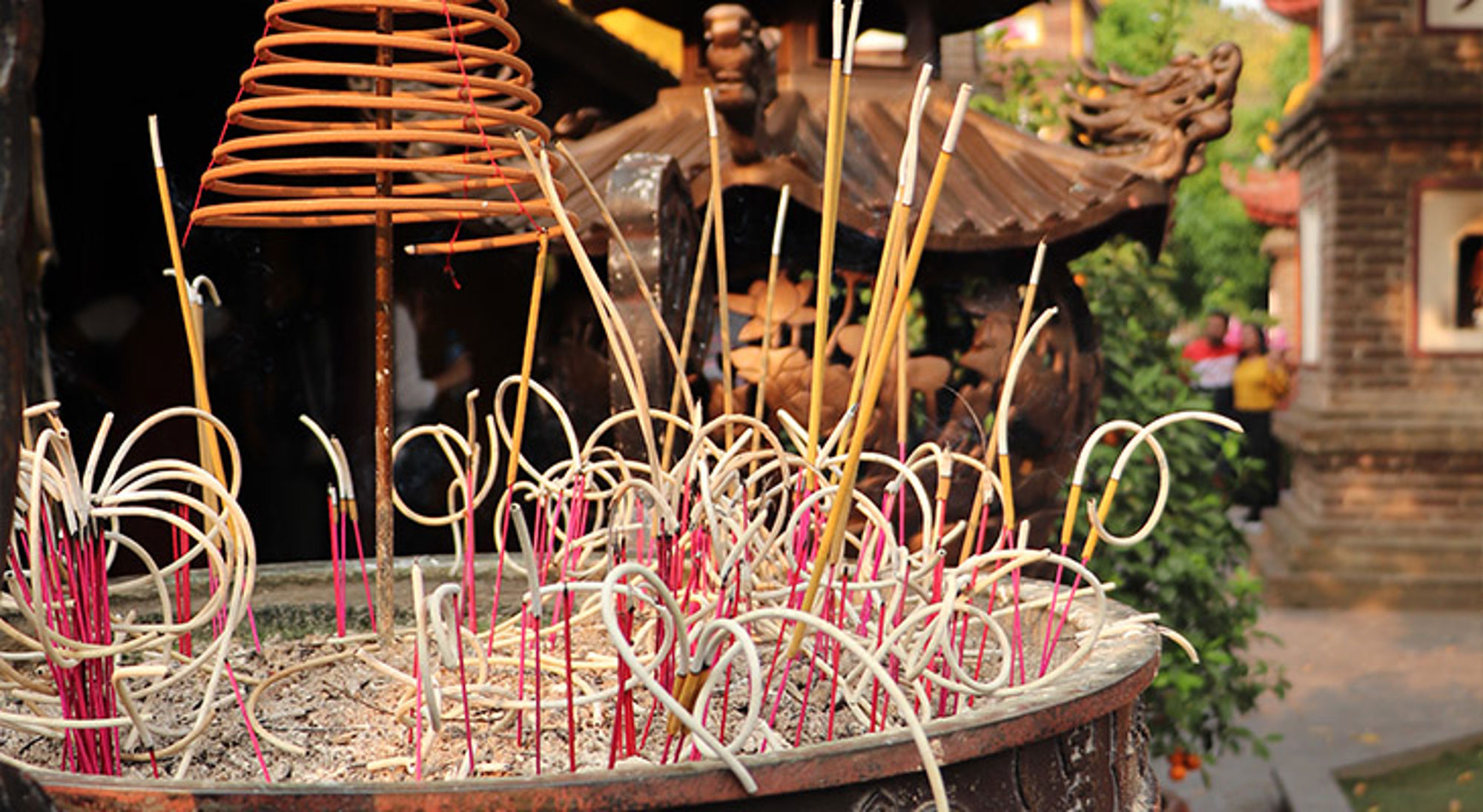Hanoi Brandende wierookstokjes in een wierookvat bij een tempel.