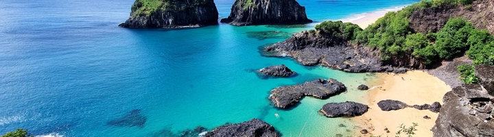 Uitzicht op Baía do Sancho met turquoise zee, rotsformaties en zandstrand op Fernando de Noronha, Brazilië.