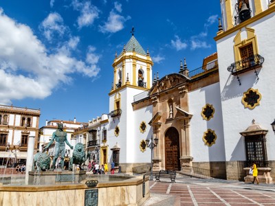 Kerk aan een plein met fontein en standbeeld in Ronda, tijdens familiereis Spanje & Portugal.