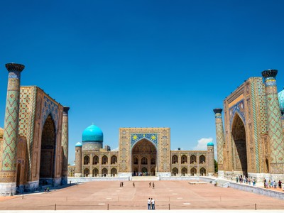 Registanplein in Samarkand, Oezbekistan, met kleurrijke madrassa’s en turquoise koepels onder een heldere blauwe lucht.