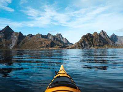Kajaktocht over een Noorse fjord met bergtoppen op de achtergrond, Route Noorwegen.