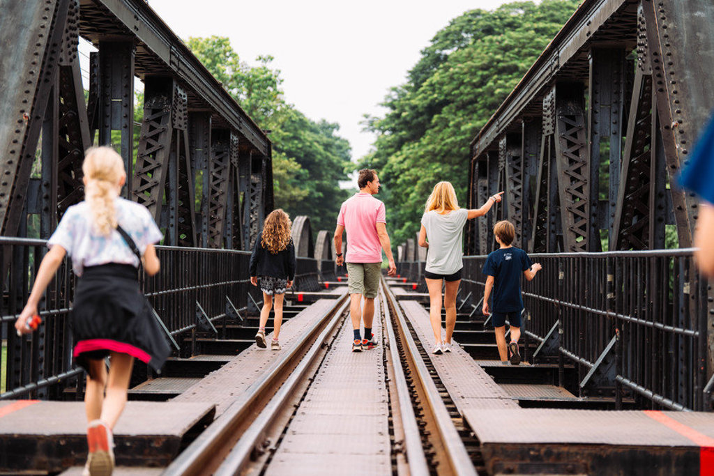 Gezin wandelt over de spoorbrug aan de River Kwai tijdens familiereis Thailand Noord en Zuid.