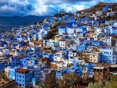 Uitzicht op Chefchaouen met blauwgeschilderde huizen tegen de bergen in Marokko.
