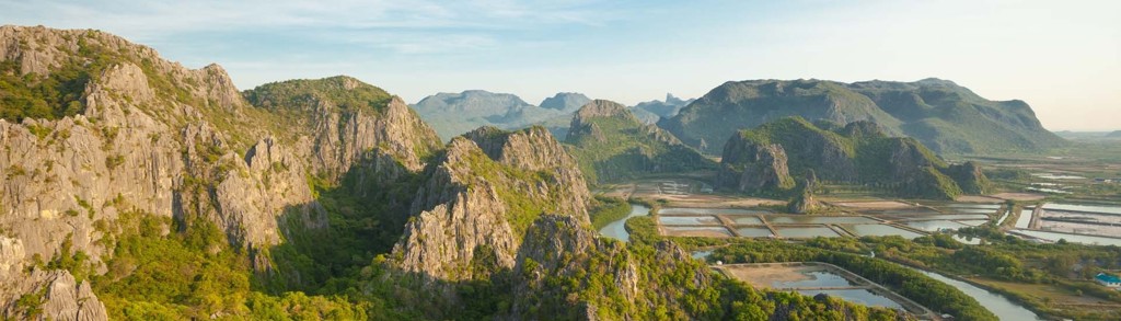 Panoramisch uitzicht op kalksteenbergen en rijstvelden in Thailand tijdens een groepsrondreis avontuur.