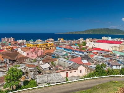 Uitzicht over Baracoa met kleurrijke daken en de Caribische Zee op de achtergrond.
