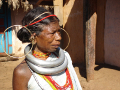 Portret van vrouw met grote oorringen en metalen halsringen in een dorp in Orissa, India.