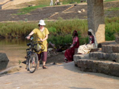 Fietser bij tempeltrappen aan de rivier tijdens de route door Zuid-India.
