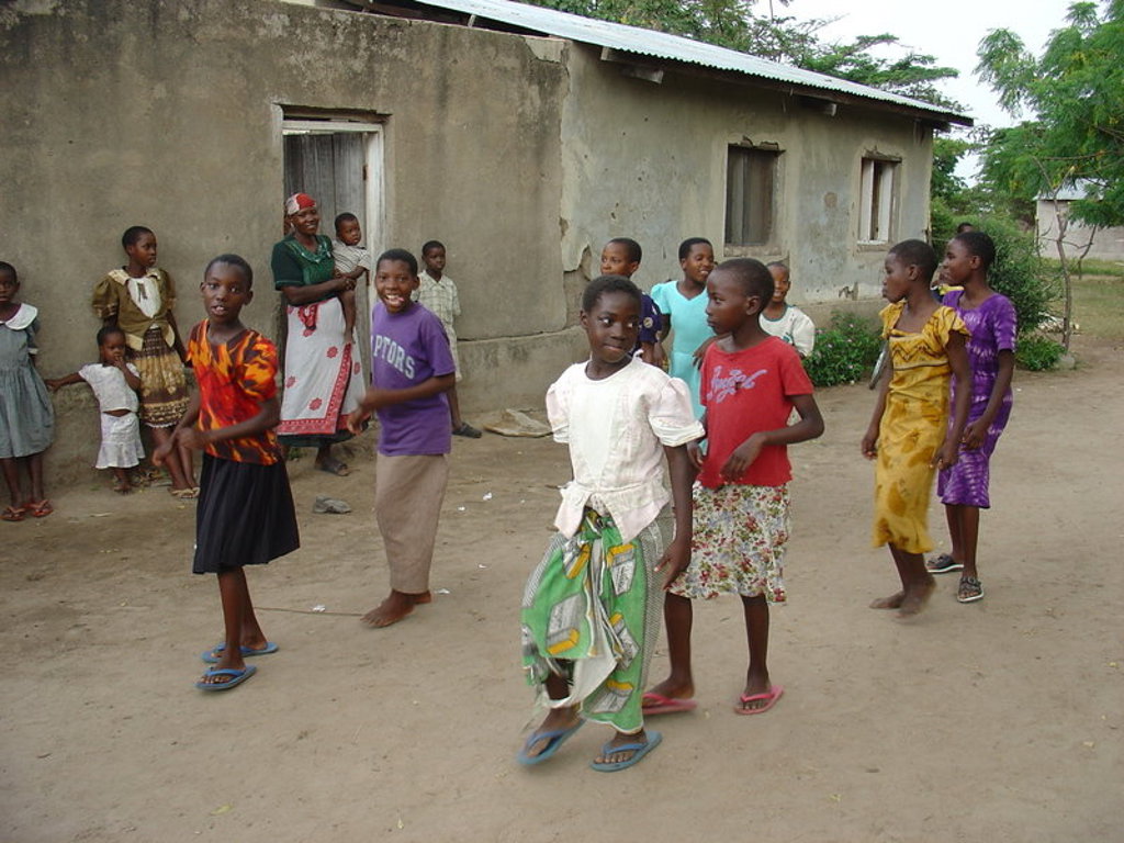 Kinderen en vrouwen bij een huis in een dorp tijdens de groepsrondreis Kenia en Tanzania Totaal.