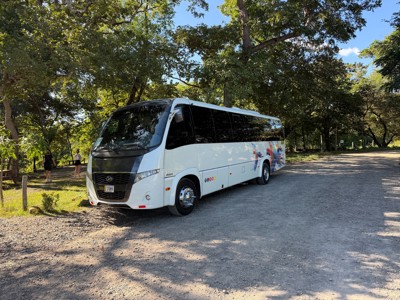Witte touringcar op onverharde weg in Costa Rica, vervoer tijdens rondreis 22-35ers en hoogtepunten.