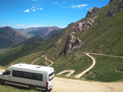 Minibus op een kronkelende bergweg in Kirgistan tijdens de Route Kirgistan.