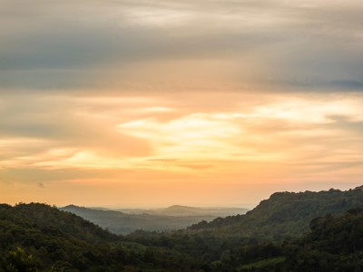 Zonsondergang boven groene heuvels en junglelandschap in Cambodja tijdens de 21-daagse route Cambodja en Thailand.