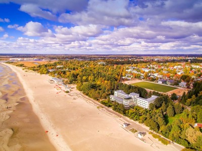 strand en kustplaats aan de Oostzee in Polen, met duinen, bos en bebouwing.