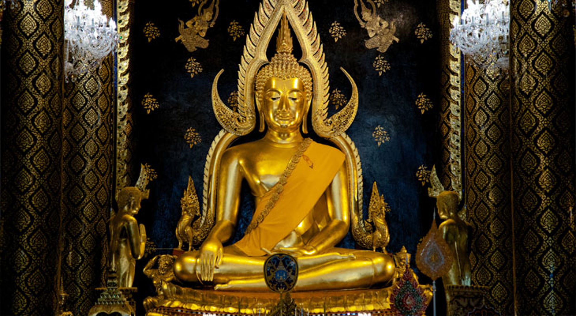 Buddha Phitsanulok Gouden Boeddhabeeld in een Thaise tempel, zittend in meditatie met sierlijke achtergronddecoratie.