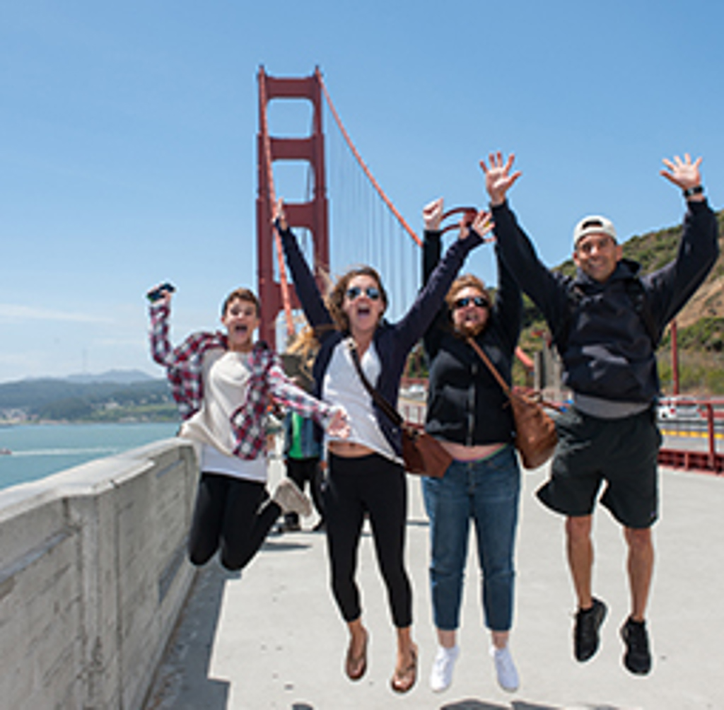 Gezin springt juichend op de Golden Gate Bridge in San Francisco tijdens familiereis door de Verenigde Staten.