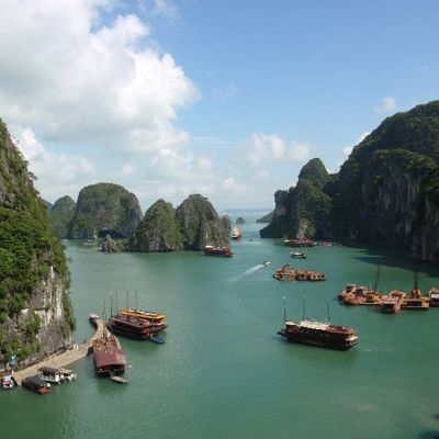 Groepsrondreis Vietnam: boten tussen kalkstenen rotsen in Halong Bay.