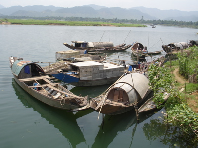 Woonboten en vissersboten aan de oever van de Parfumrivier bij Hué, Route Vietnam.