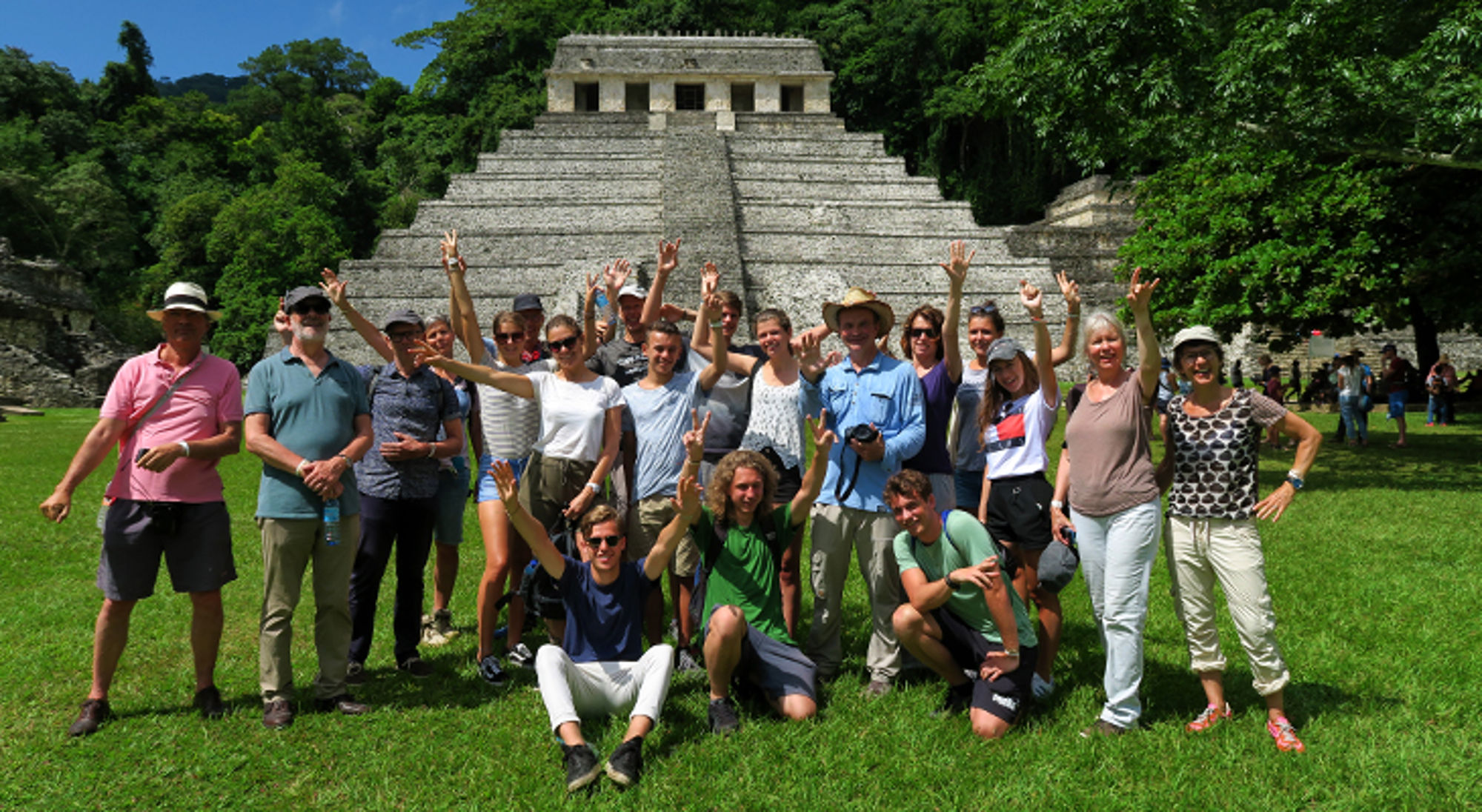 Groepsfoto van reizigers voor de Maya-tempel van Palenque in Mexico.